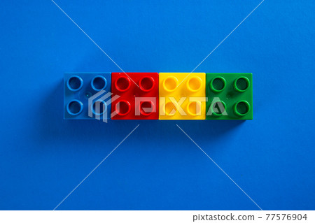 Color plastic building blocks on blue background 77576904