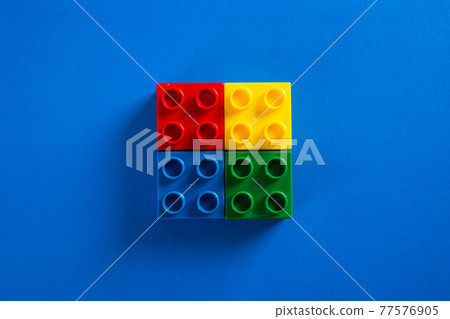 Color plastic building blocks on blue background Color plastic building blocks on blue background 77576905