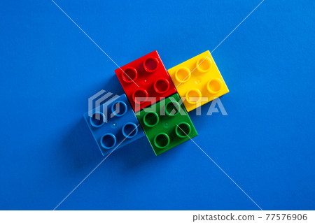 Color plastic building blocks on blue background Color plastic building blocks on blue background 77576906