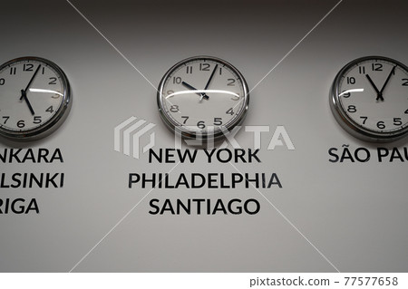 Many wall clocks on the white wall of business office showing time of different cities of the world 77577658