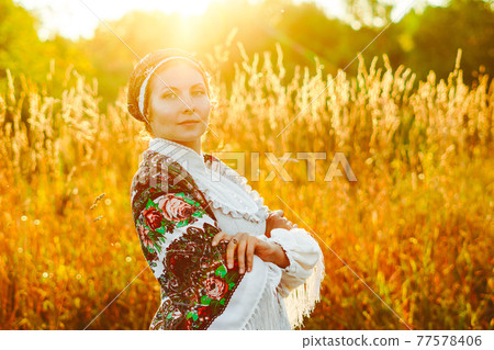 a girl in a national costume at sunset 77578406