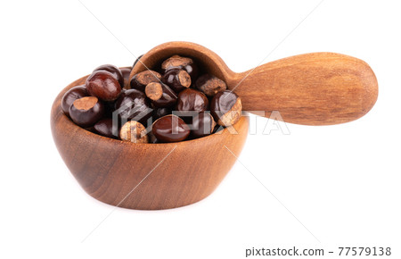 Guarana seed in wooden bowl and spoon, isolated on white background. Dietary supplement guarana, caffeine cource for energy drinks. 77579138