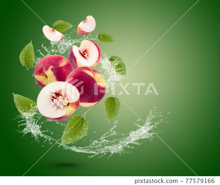 Water splash on fresh peach with leaves isolated on green background. Water splash on fresh peach with leaves isolated on green background. 77579166