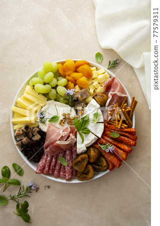 Charcuterie assortment, variety of cheeses and salami, prosciutto and dried fruits, figs, apricots, cranberries. 77579311