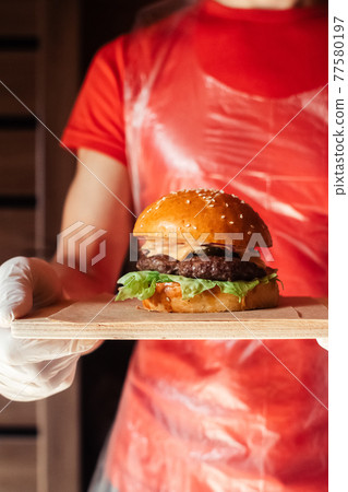 Mini burger on a stand close-up. Children fast food in a restaurant or cafe. Macro photo of burger ingredients with meat and vegetables. Eco burgers for children Mini burger on a stand close-up. Children fast food in a restaurant or cafe. Macro photo of burger ingredients with meat and vegetables. Eco burgers for children 77580197