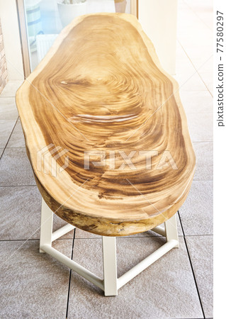Dining table of live edge suar wood slab on metal carcass in yard 77580297