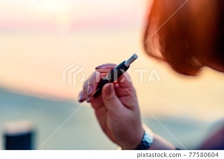 抽加熱不燃燒煙草的女人 77580604