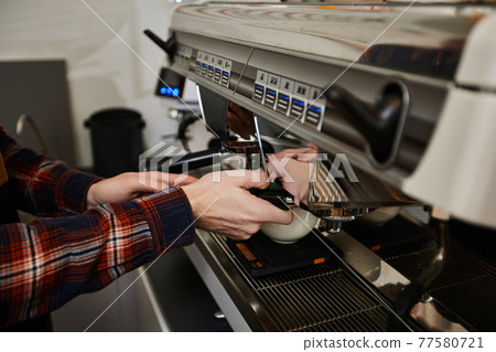Barista using a coffee machine to make coffee Barista using a coffee machine to make coffee 77580721