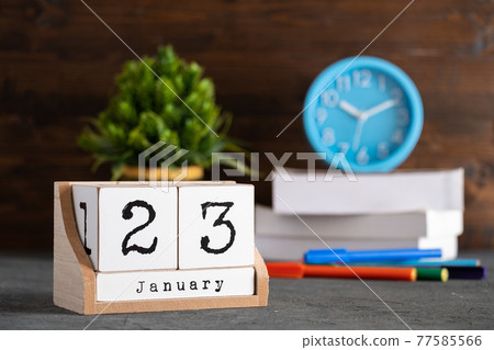 January 23rd. January 23 wooden cube calendar with blur objects on background. 77585566