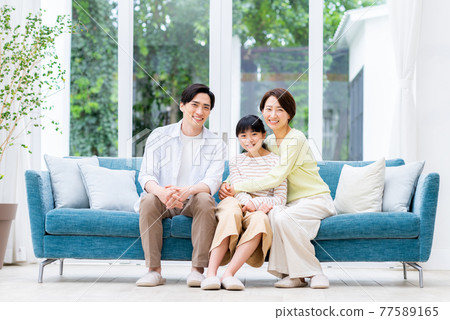 Middle family relaxing in the living room Middle family relaxing in the living room 77589165