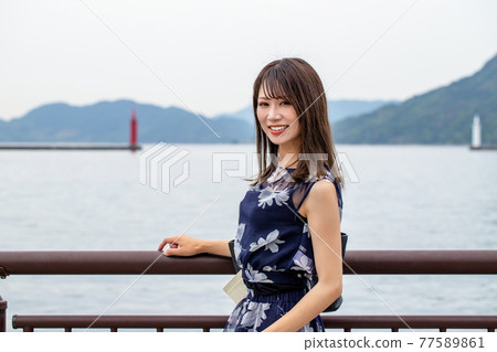 Smiling woman with ocean background 77589861