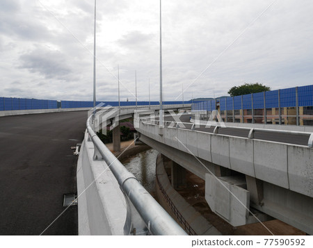 SELANGOR, MALAYSIA - JULY 5, 2020: Noise barriers are installed along the vehicle lane bordering the residence to prevent noise pollution to the surrounding locals. SELANGOR, MALAYSIA - JULY 5, 2020: Noise barriers are installed along the vehicle lane bordering the residence to prevent noise pollution to the surrounding locals. 77590592