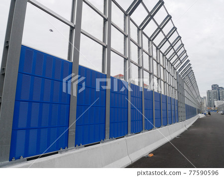 SELANGOR, MALAYSIA - JULY 5, 2020: Noise barriers are installed along the vehicle lane bordering the residence to prevent noise pollution to the surrounding locals. SELANGOR, MALAYSIA - JULY 5, 2020: Noise barriers are installed along the vehicle lane bordering the residence to prevent noise pollution to the surrounding locals. 77590596