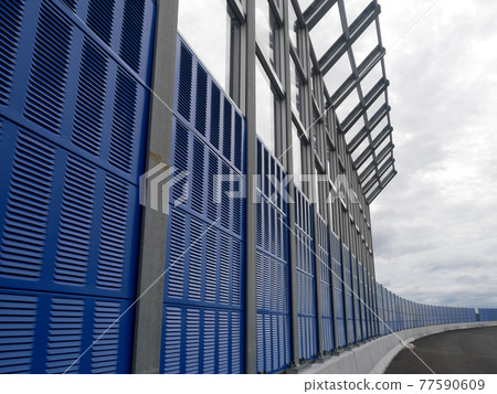 SELANGOR, MALAYSIA - JULY 5, 2020: Noise barriers are installed along the vehicle lane bordering the residence to prevent noise pollution to the surrounding locals. 77590609