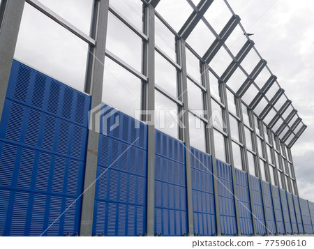 SELANGOR, MALAYSIA - JULY 5, 2020: Noise barriers are installed along the vehicle lane bordering the residence to prevent noise pollution to the surrounding locals. 77590610