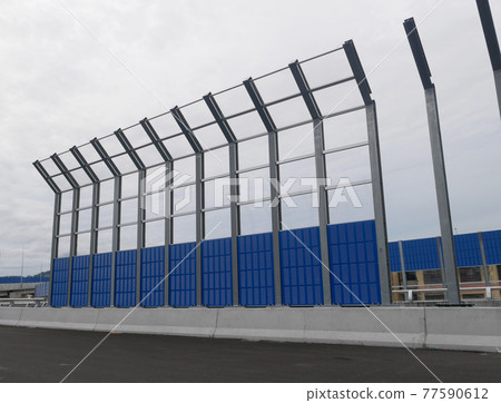 SELANGOR, MALAYSIA - JULY 5, 2020: Noise barriers are installed along the vehicle lane bordering the residence to prevent noise pollution to the surrounding locals. SELANGOR, MALAYSIA - JULY 5, 2020: Noise barriers are installed along the vehicle lane bordering the residence to prevent noise pollution to the surrounding locals. 77590612