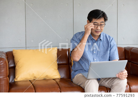 asian senior man using computer laptop at home asian senior man using computer laptop at home 77591293