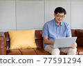 asian senior man using computer laptop at home 77591294