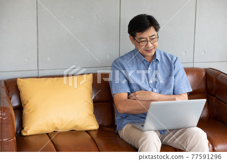 asian senior man using computer laptop at home asian senior man using computer laptop at home 77591296