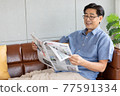 senior asian man reading a newspaper  77591334