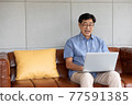 asian senior man using computer laptop at home 77591385