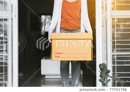 Woman holding paper box from delivery service during coronavirus pandemic situation at home Woman holding paper box from delivery service during coronavirus pandemic situation at home 77591786