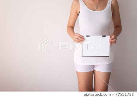 Woman hands holding a white calenda empty on white background Woman hands holding a white calenda empty on white background 77591788