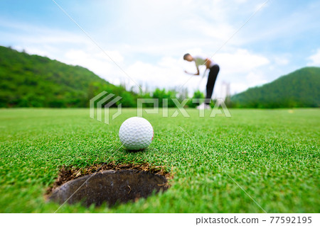 Close up golf ball on green grass field 77592195