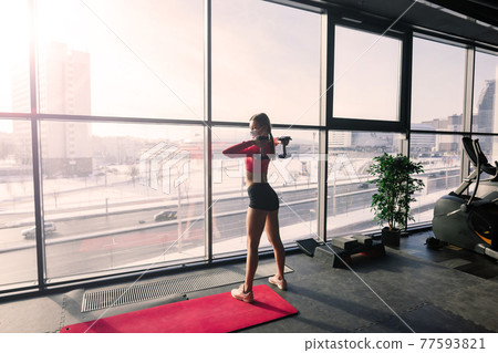 Woman wearing face mask exercise workout in gym during corona virus pandermic. 77593821