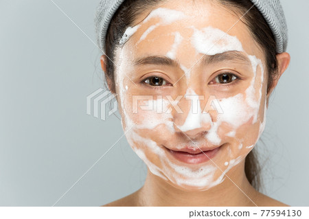 Woman putting foam on face Woman putting foam on face 77594130