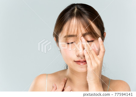 A woman holding a nose A woman holding a nose 77594141