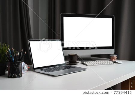 Home office with computer, laptop and supplies on white desk. Home office with computer, laptop and supplies on white desk. 77594415