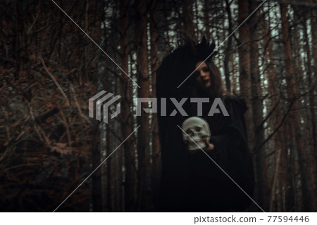 blurred mystical silhouette of an evil scary witch with a dead man's skull in a mirror blurred mystical silhouette of an evil scary witch with a dead man's skull in a mirror 77594446