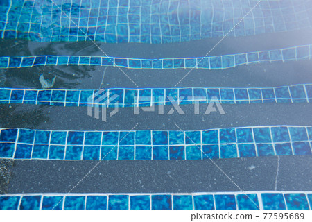 Wavy blue tiles in a swimming pool create an abstract pattern Wavy blue tiles in a swimming pool create an abstract pattern 77595689