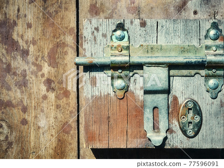 Close up picture of a hasp on a wooden door. Close up picture of a hasp on a wooden door. 77596091