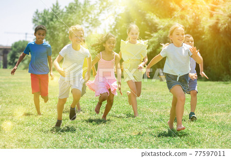 Happy kids running in race in the street and laughing Happy kids running in race in the street and laughing 77597011