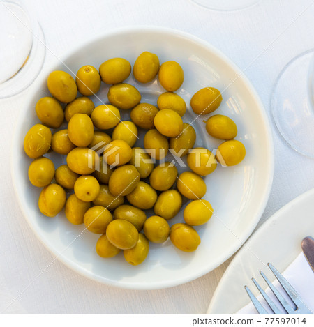 Traditional Spanish appetizer marinated whole green olives 77597014