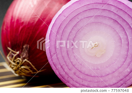 Close up'Red onion on a black background. Close up'Red onion on a black background. 77597048