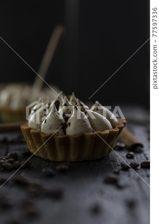 Cappuccino tart with cinnamon sticks and coffee beans on rustic wooden table 77597336