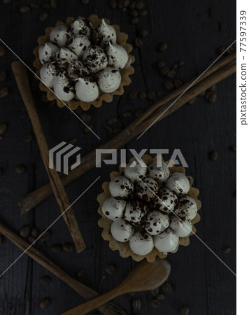 Cappuccino tart with cinnamon sticks and coffee beans on rustic wooden table Cappuccino tart with cinnamon sticks and coffee beans on rustic wooden table 77597339