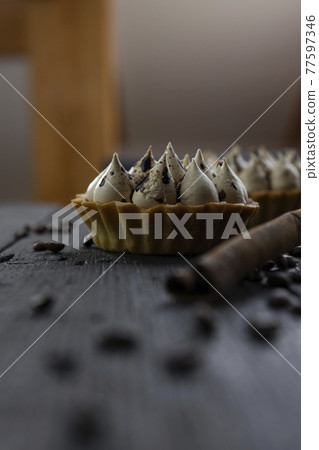 Cappuccino tart with cinnamon sticks and coffee beans on rustic wooden table 77597346