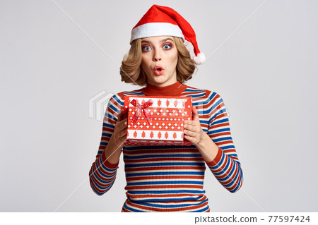 happy woman with christmas gifts in hands and red hat on head new year holidays cropped view 77597424
