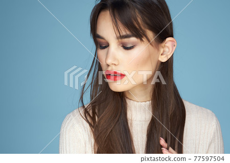 Brunette in a white sweater red lips charm long hair blue background 77597504