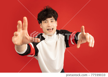 Asian man's portrait isolated over red studio background with copyspace 77599010