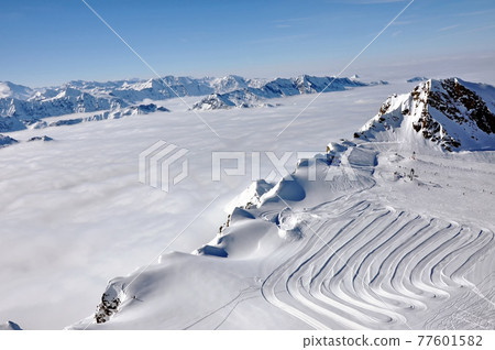 Ski resort in the Alps. Ski slopes, piste, powder snow in the mountains Ski resort in the Alps. Ski slopes, piste, powder snow in the mountains 77601582
