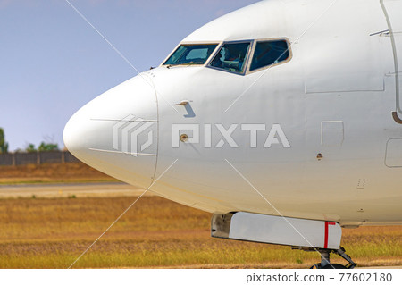 Cockpit of big passenger airliner on runway close up 77602180