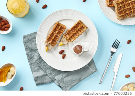 Oatmeal Belgian waffles in pencil shape on blue table. Flat lay top view 77603236