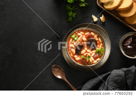 Spanish asturiana fabada with chorizo and morcilla on black background. 77603292