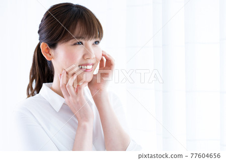 A woman who feels moisturized skin A woman who feels moisturized skin 77604656
