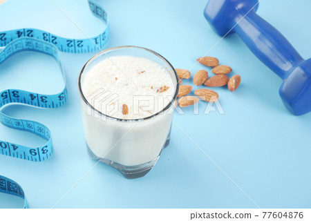 measurement tape, almond nut and milk on blue measurement tape, almond nut and milk on blue 77604876